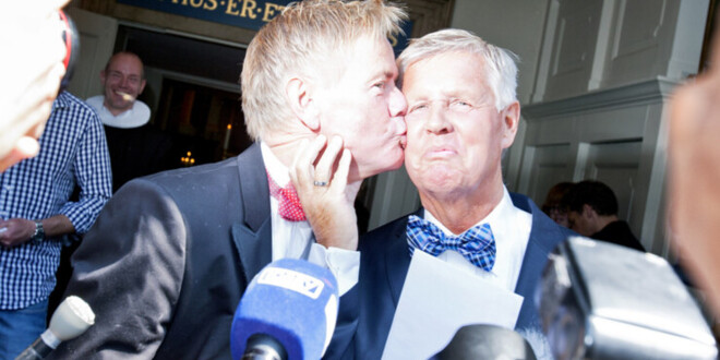 En ældre mand kigger sin mand på kinden efter vielse i kirke