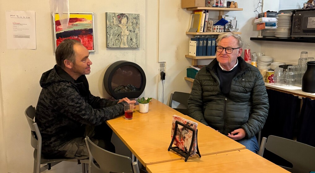 Gæsterne Sten og Niels Jørgen snakker inden maden serveres i suppekøkkenet