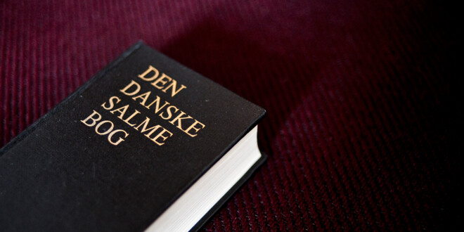 Den danske salmebog på bordeaux baggrund.