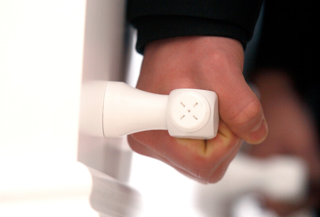 En hånd løfter i håndtaget på en hvid kiste.