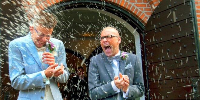 To nygifte mænd træder ud af kirkedøren efter vielse og bliver mødt af riskast