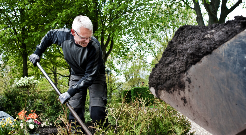 Billede af graver, der luger på kirkegård