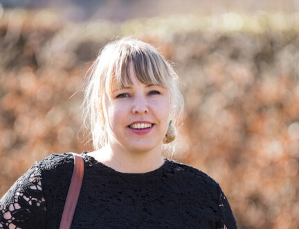 Ung kvinde med blond pandehår smiler til kameraet