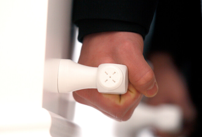 En hånd løfter i håndtaget på en hvid kiste.