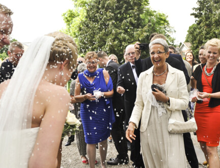 Gæster kaster ris på brudepar uden foran kirken