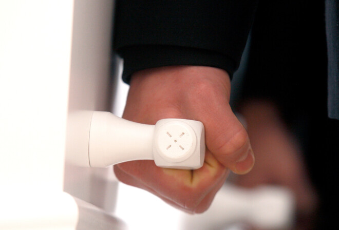 En hånd løfter i håndtaget på en hvid kiste.